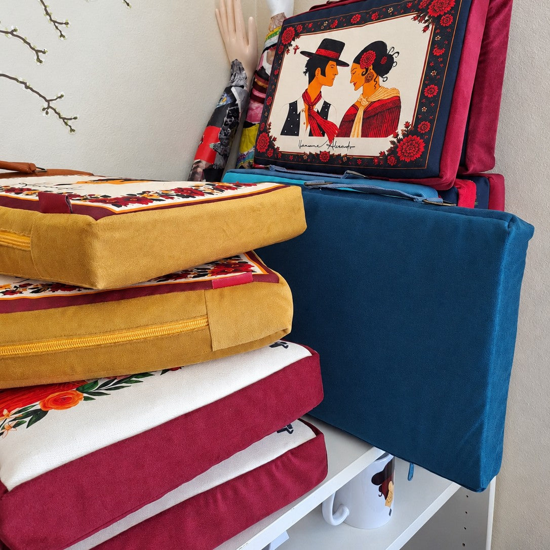 Almohadillas Alocado apiladas en terciopelo mostaza, granate y azul
