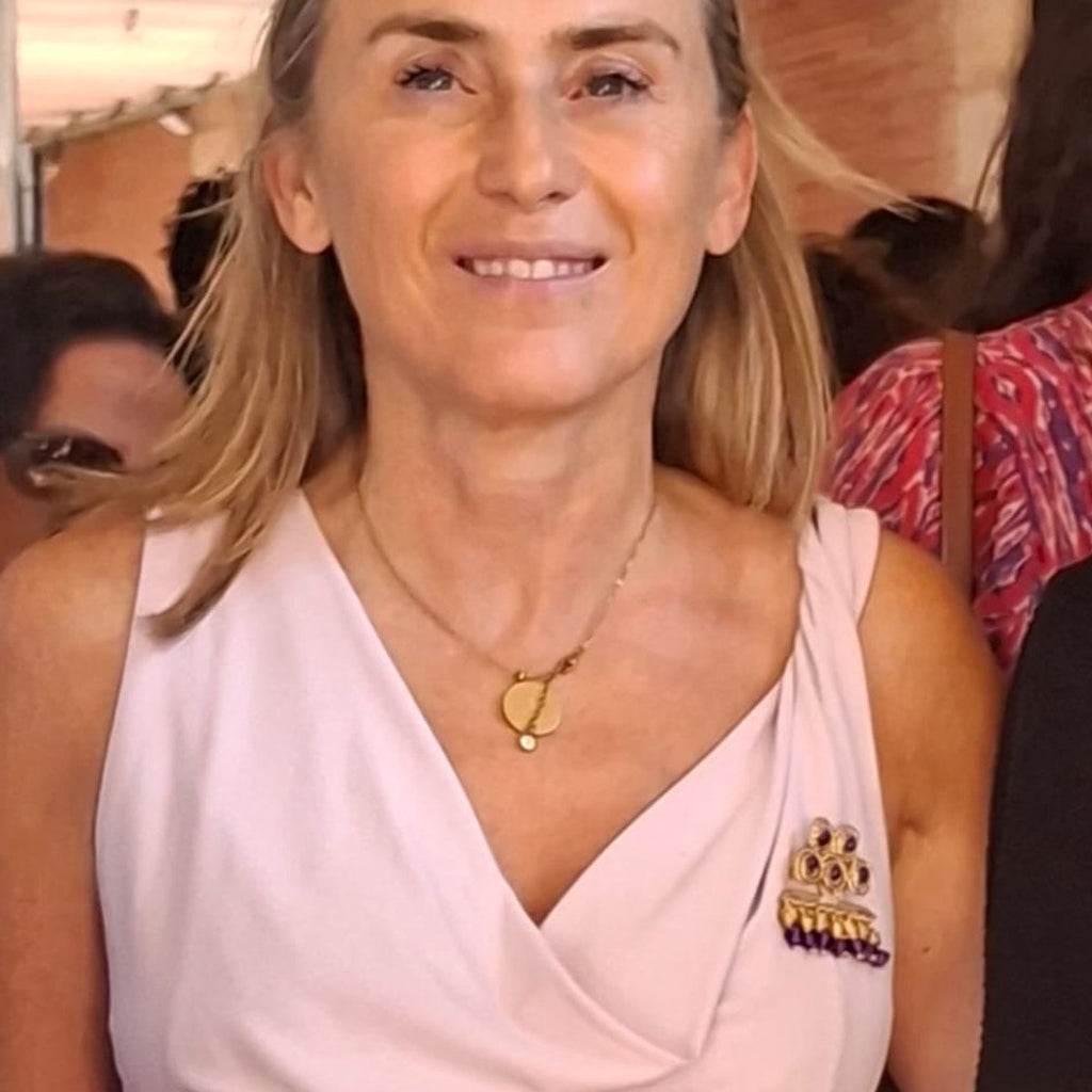 Mujer luciendo un broche de alambre dorado Una de Belén sobre top rosa